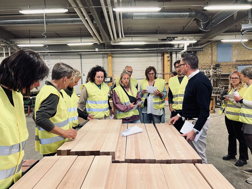 Lärare från Amsterdam i gula västar på visning bland virket i Sjöbergs fabrik