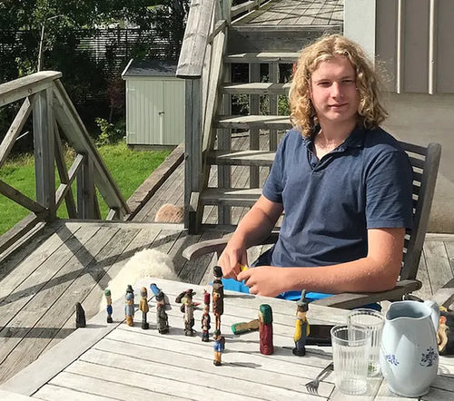 Adrian Nilsson Markung vid ett bord med sina snidade träfigurer