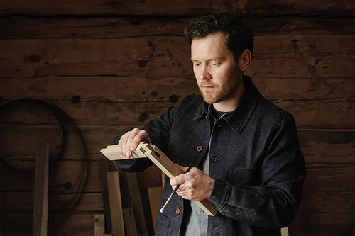 Fredrik Ireklint i sin verkstad med ett arbetsstycke i trä